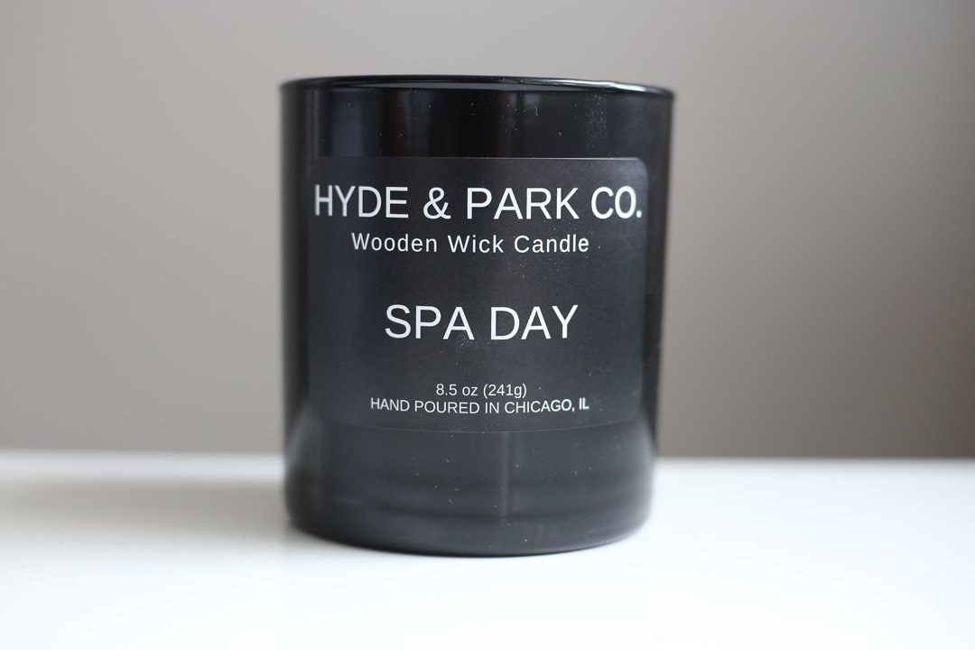 A black candle with white text that says &quot;Spa Day&quot; 