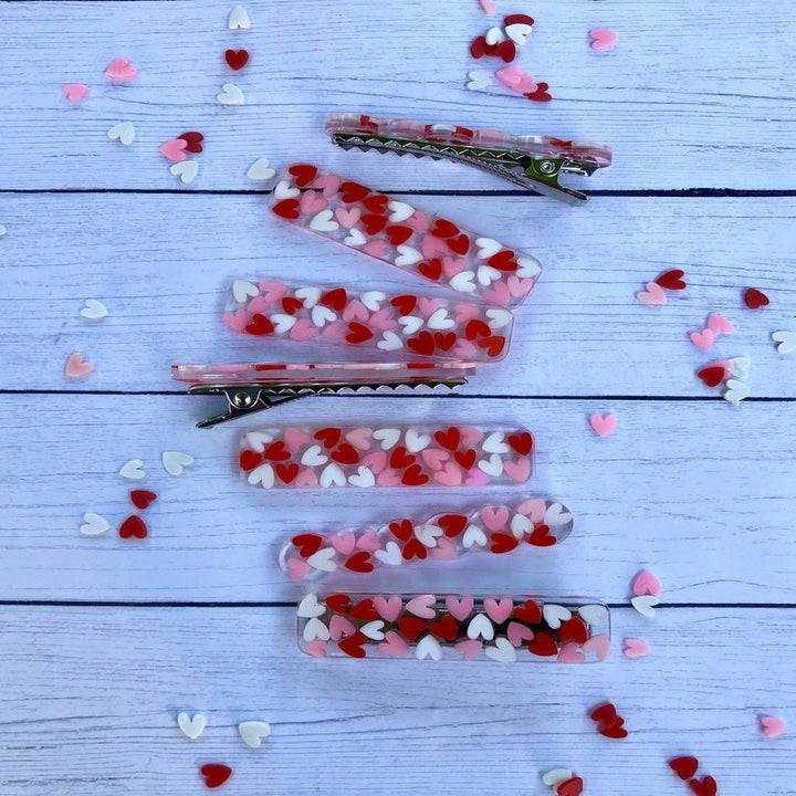 the clear hair clips with pink, red, and white hearts on them 