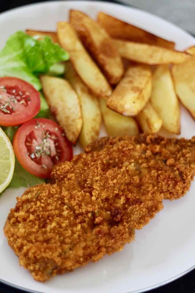 A plate of milanesas with fries and salad