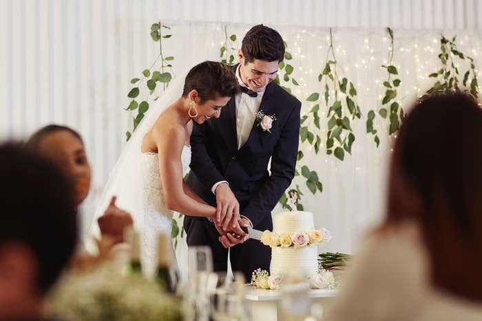 A happy couple cutting the cake at their wedding reception