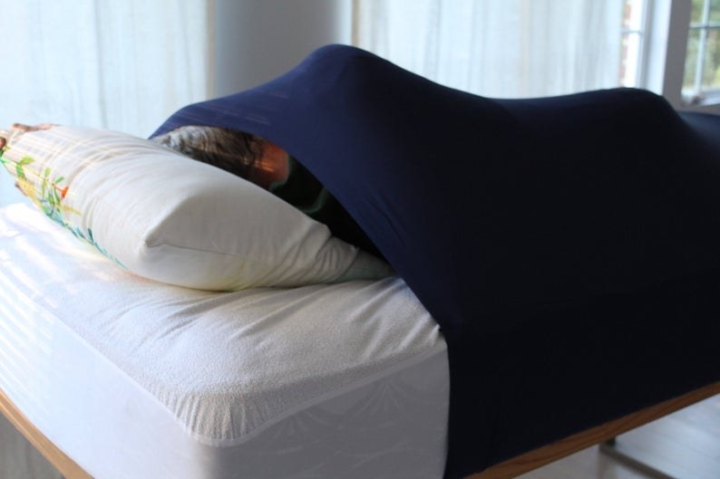 a person in bed with the compression sheet stretched over them 