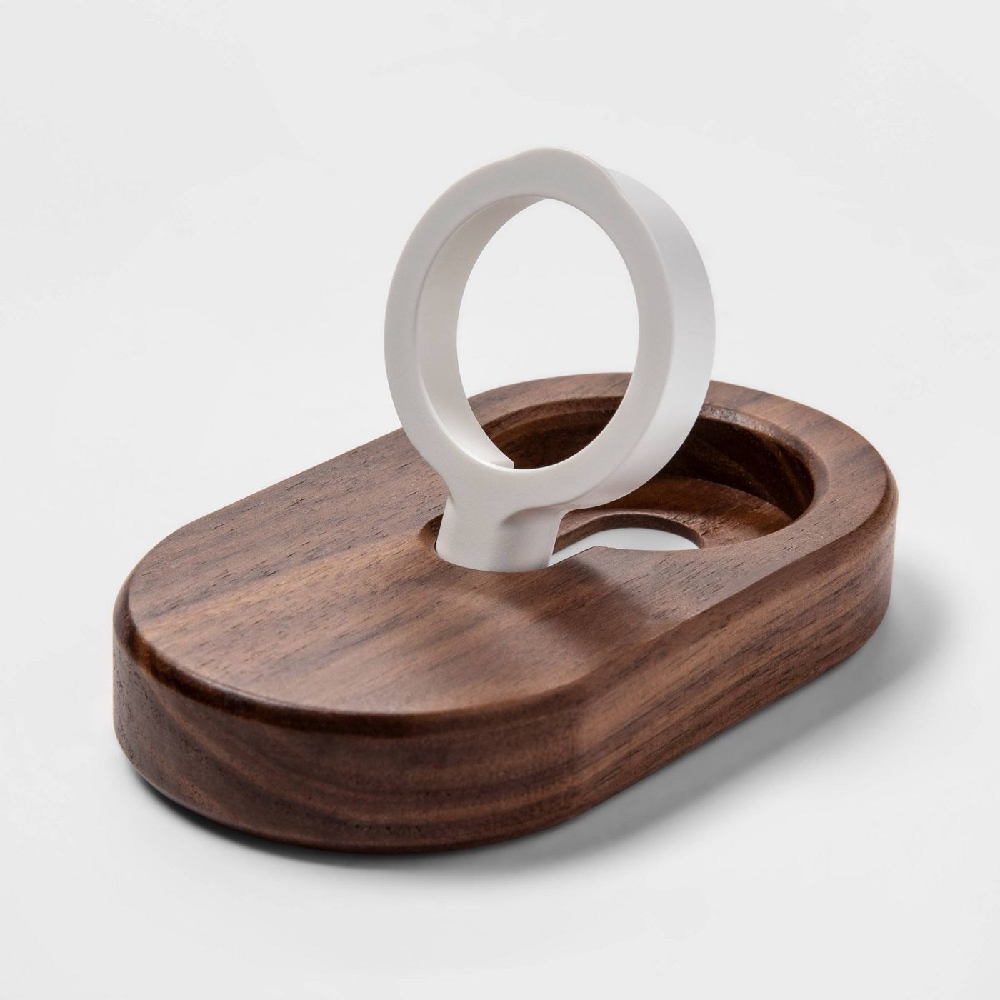 The stand, which has an oval wood base, and a round pop-out watch holder