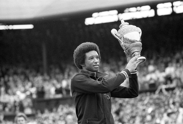 Arthur Ashe holding Wimbledon trophy