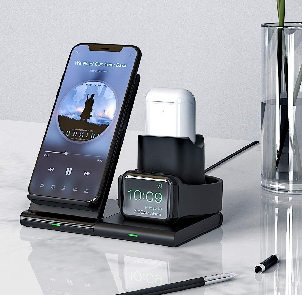 A phone, airpods case, and apple watch charging together on the charging platform 