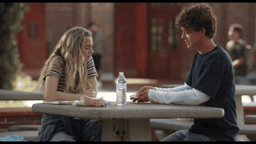 boy and girl sit at table talking