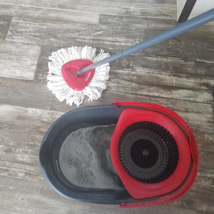 A reviewer photo showing a top-down view of the mop wiping hardwood floor and the bucket filled with water 
