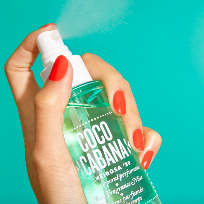 A close up of someone spraying the body mist into the air