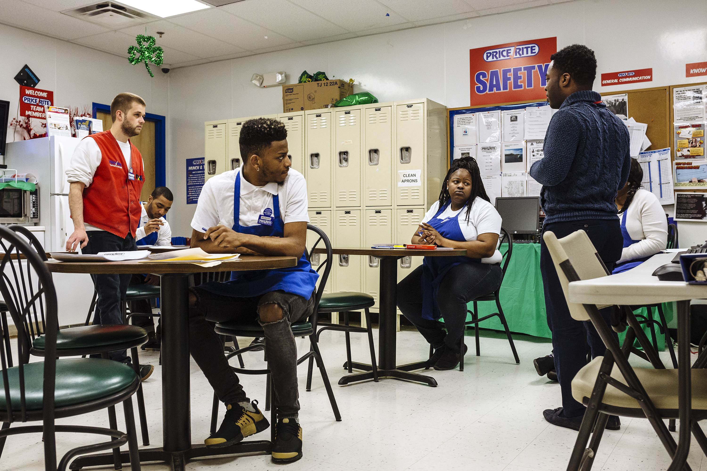 Trainees in Price Rite aprons in a locker room for a supermarket