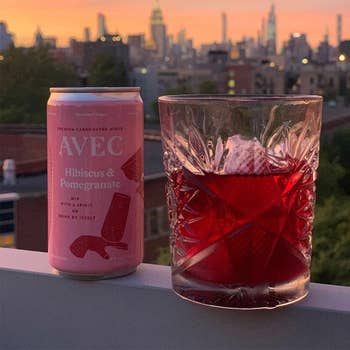 A pomegranate can and cup with ice and juice on ledge
