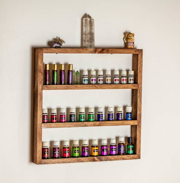 The three-tier shelf holding various bottles of essential oil