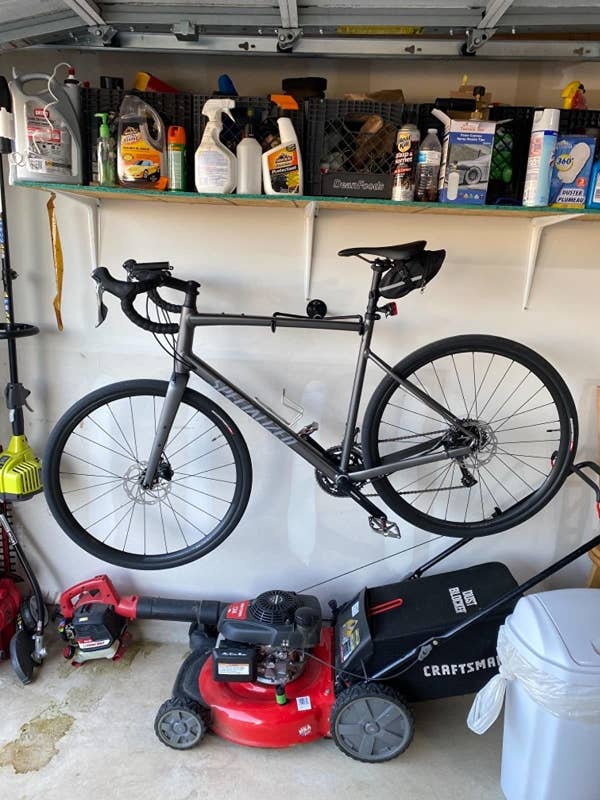 A reviewer's photo of their bike hanging from the mount in their garage