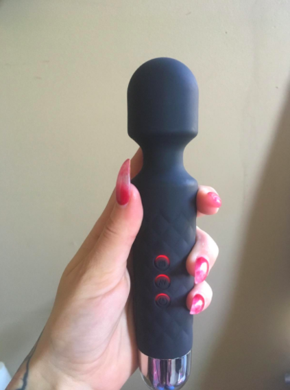 a reviewer holding the black mini wand