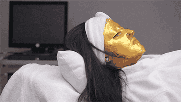 Someone wearing a gold face mask at the spa