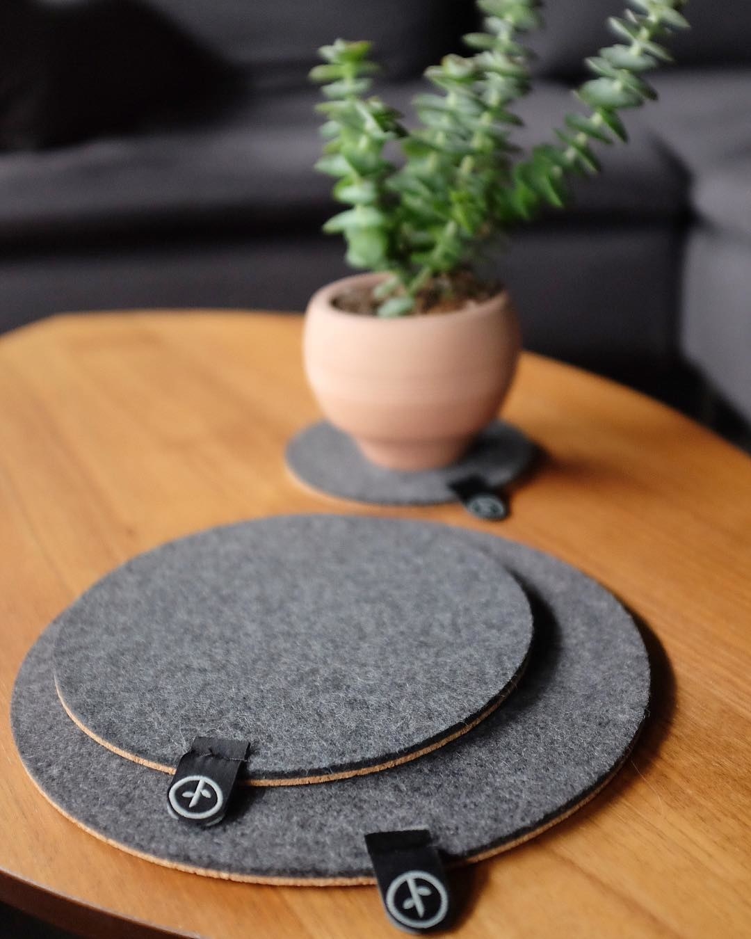 A plant pot on a trivet and two trivets on a table