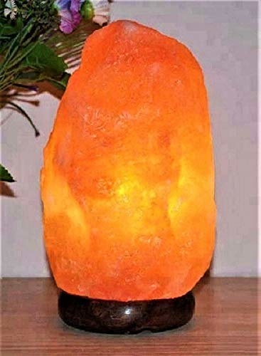 An orange Himalayan rock salt lamp on a table 