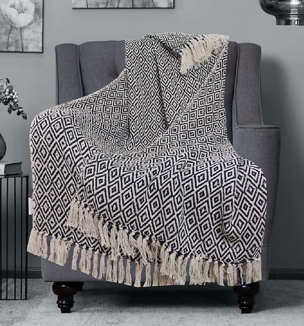 A diamond patterned throw blanket on a grey chair 