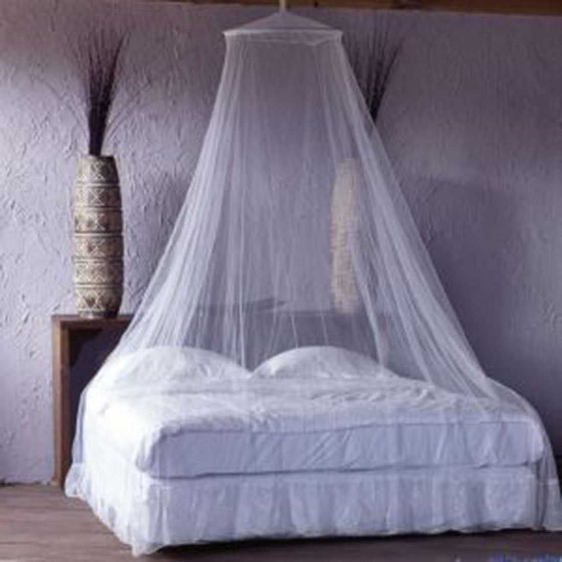 A white canopy hanging over a white bed 