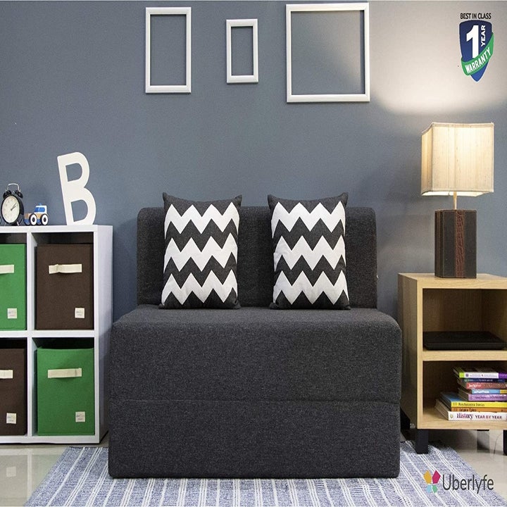 A grey sofa-cum-bed in sofa form
