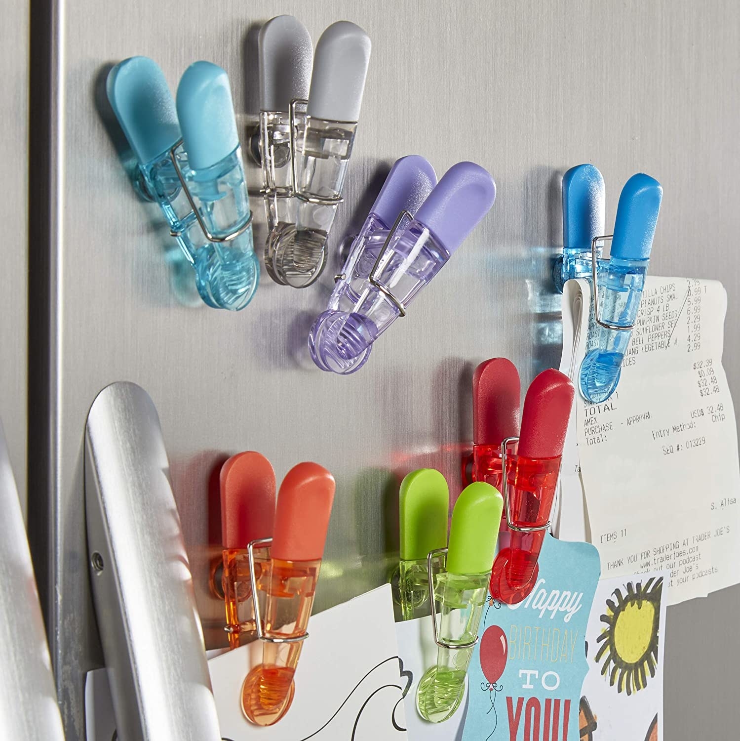 A bunch of magnetic clips stuck to a fridge door