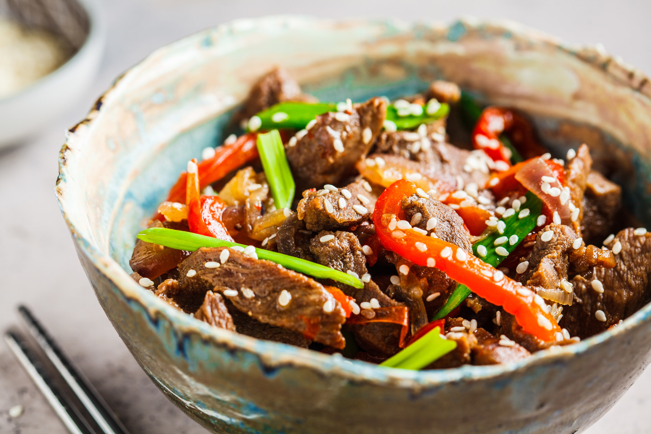 A bowl of steak stir fry with peppers.