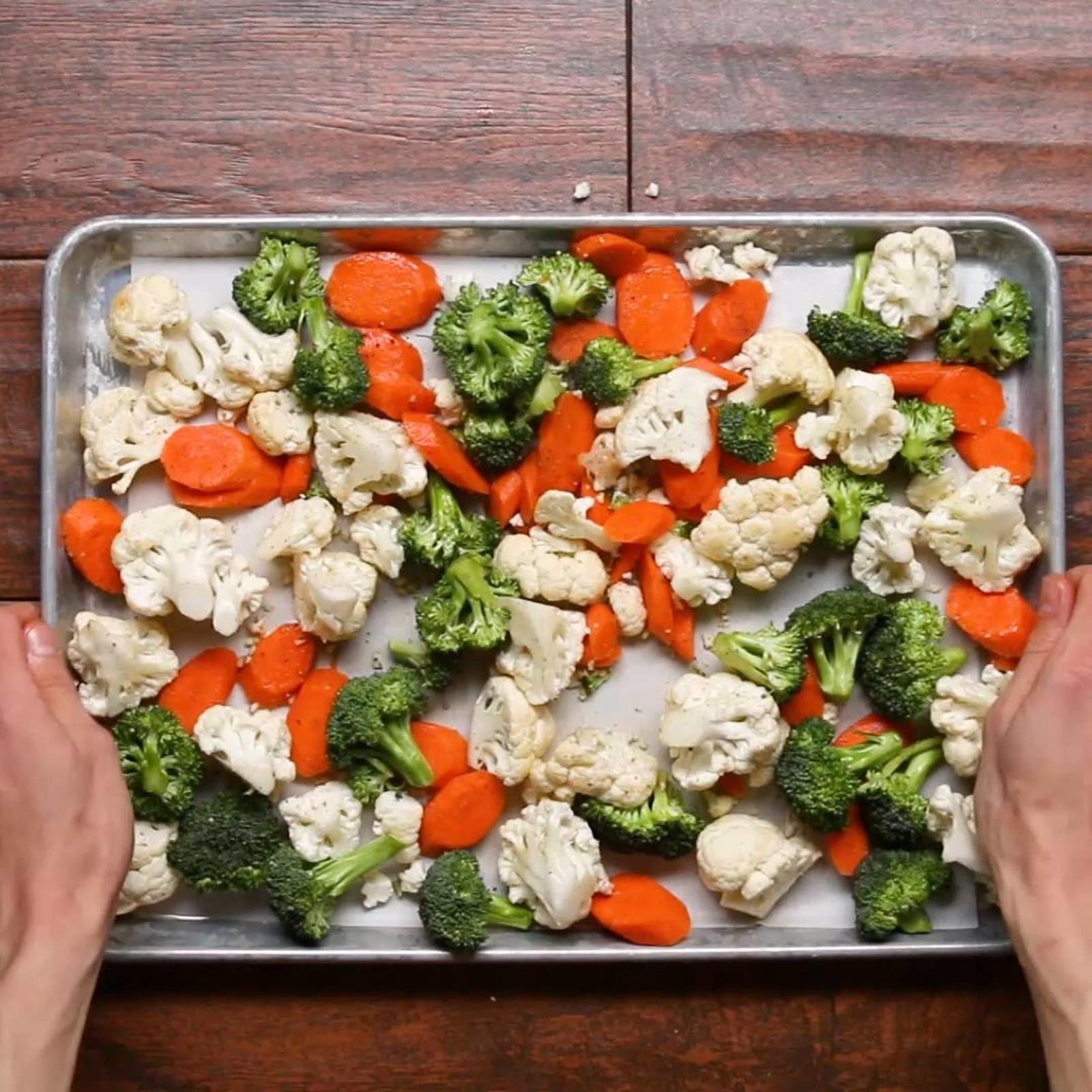 Cauliflower, broccoli, and carrots on a sheet pan.