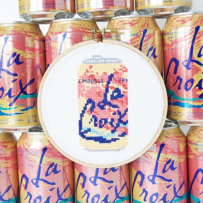 The cross stitch in front of cans of La Croix