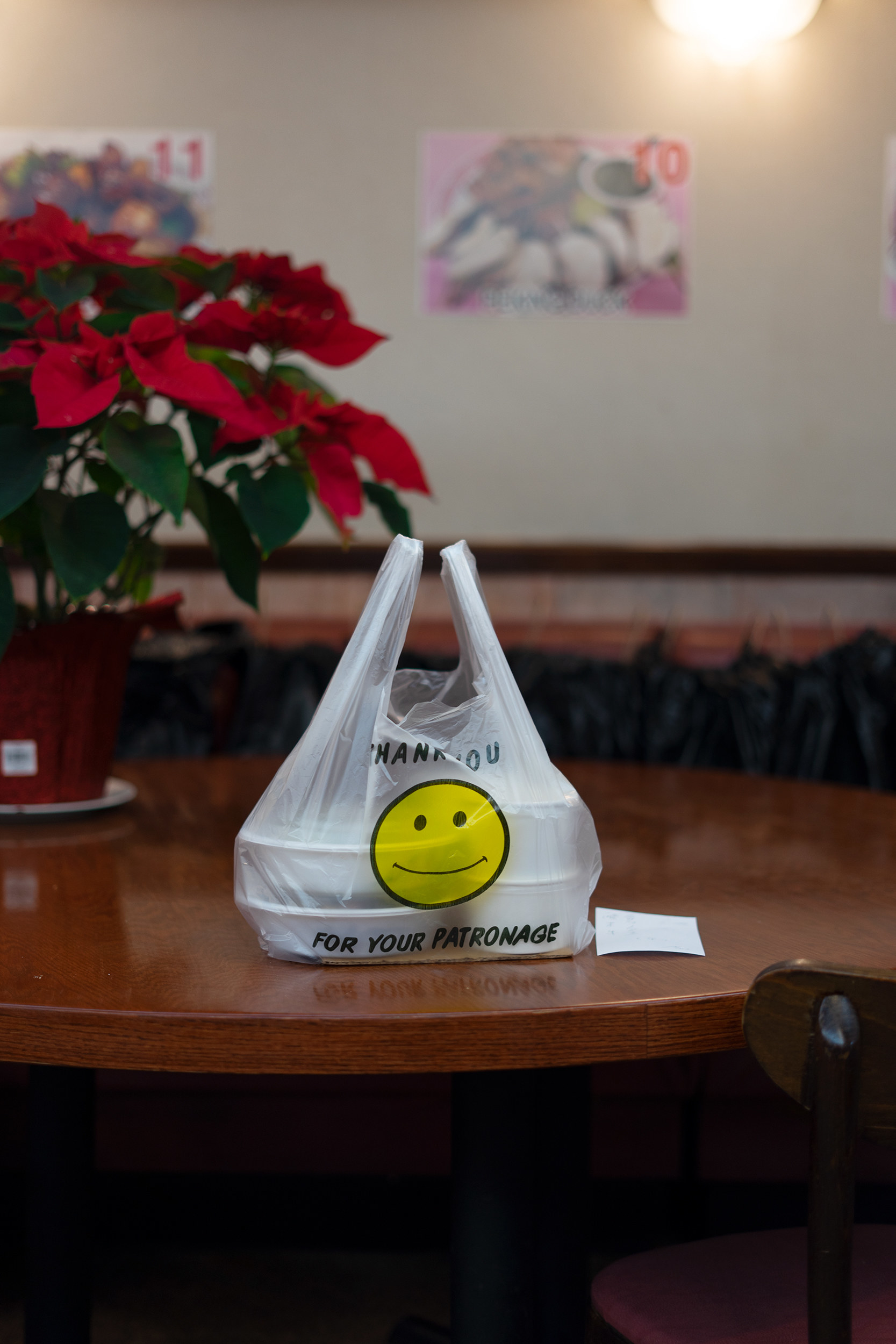 A bag with a smiley face on it at an empty table