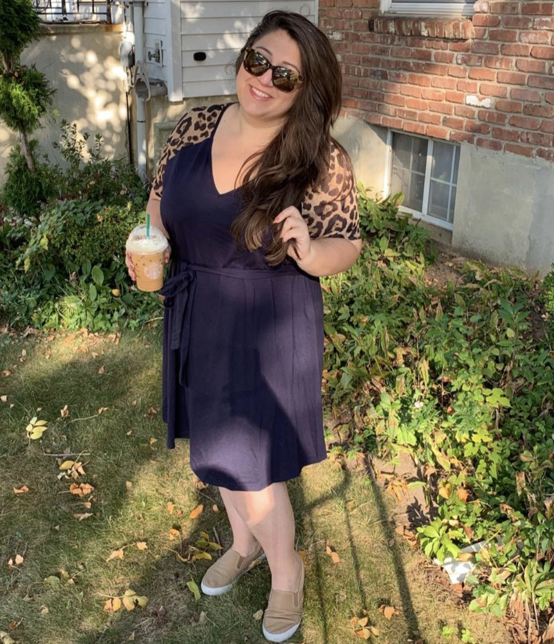 reviewer wearing the navy blue dress with leopard print sleeves