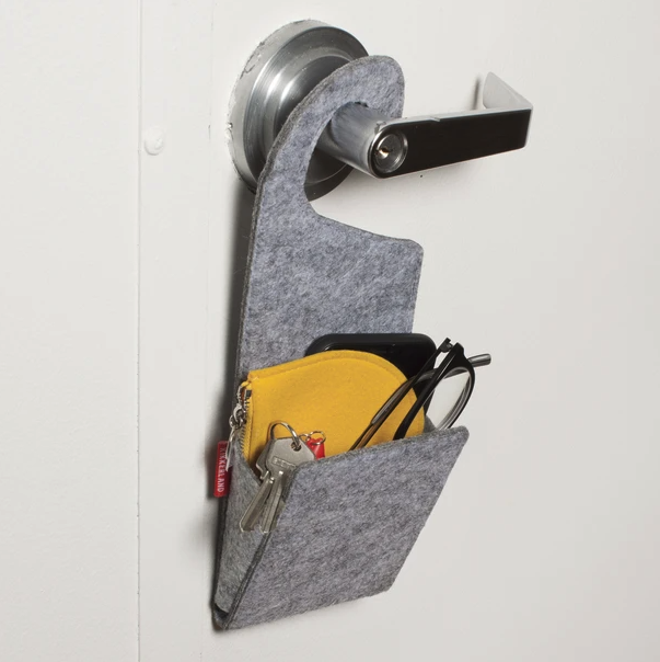 The doorknob pocket filled with keys, a wallet, phone, and glasses