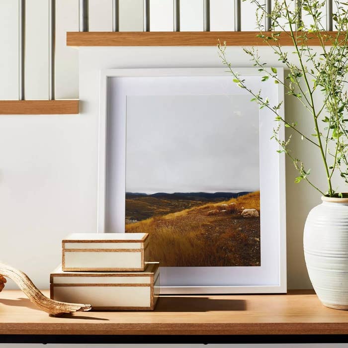 The piece of framed wall art in a white frame