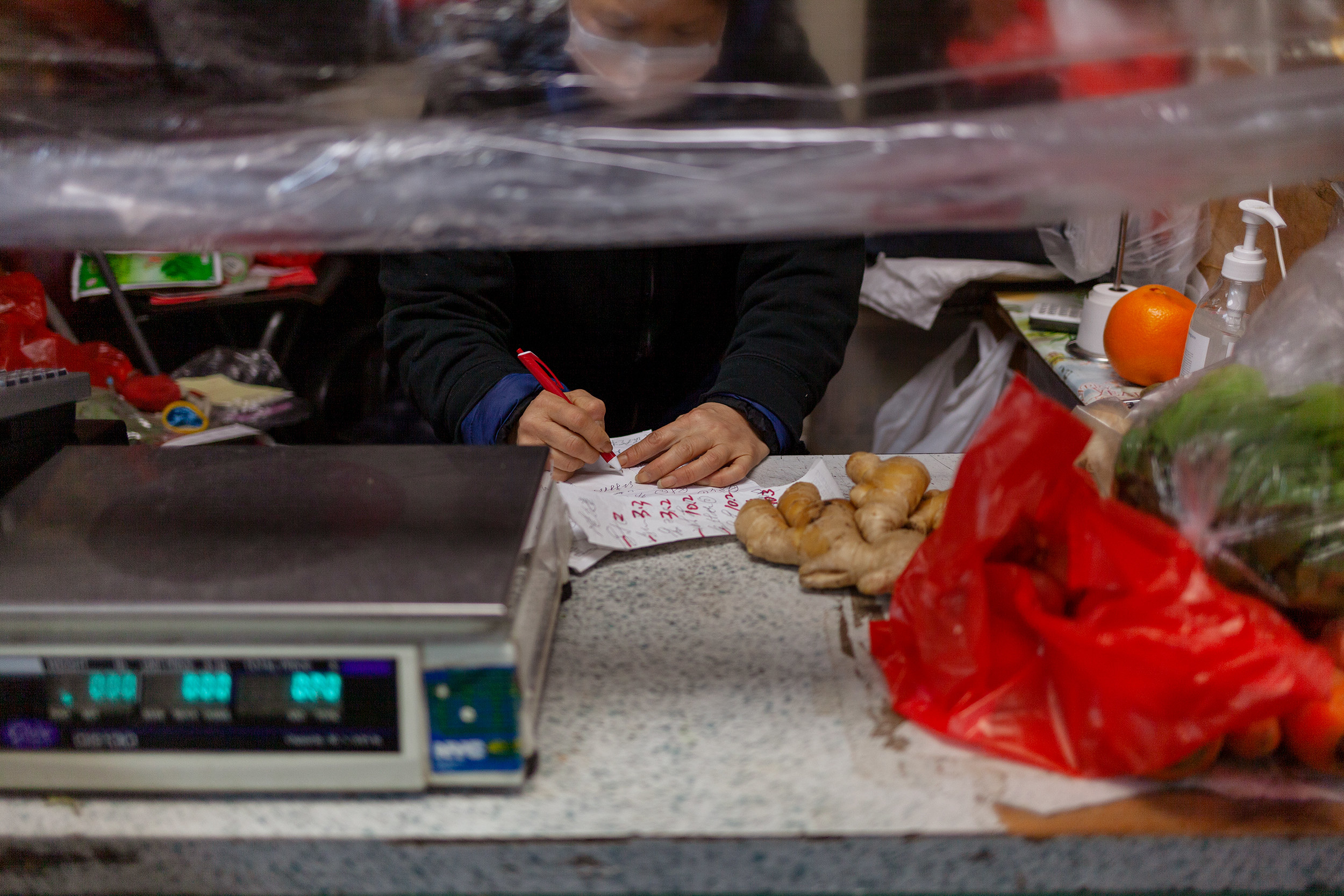 A woman writing down information next to a scale