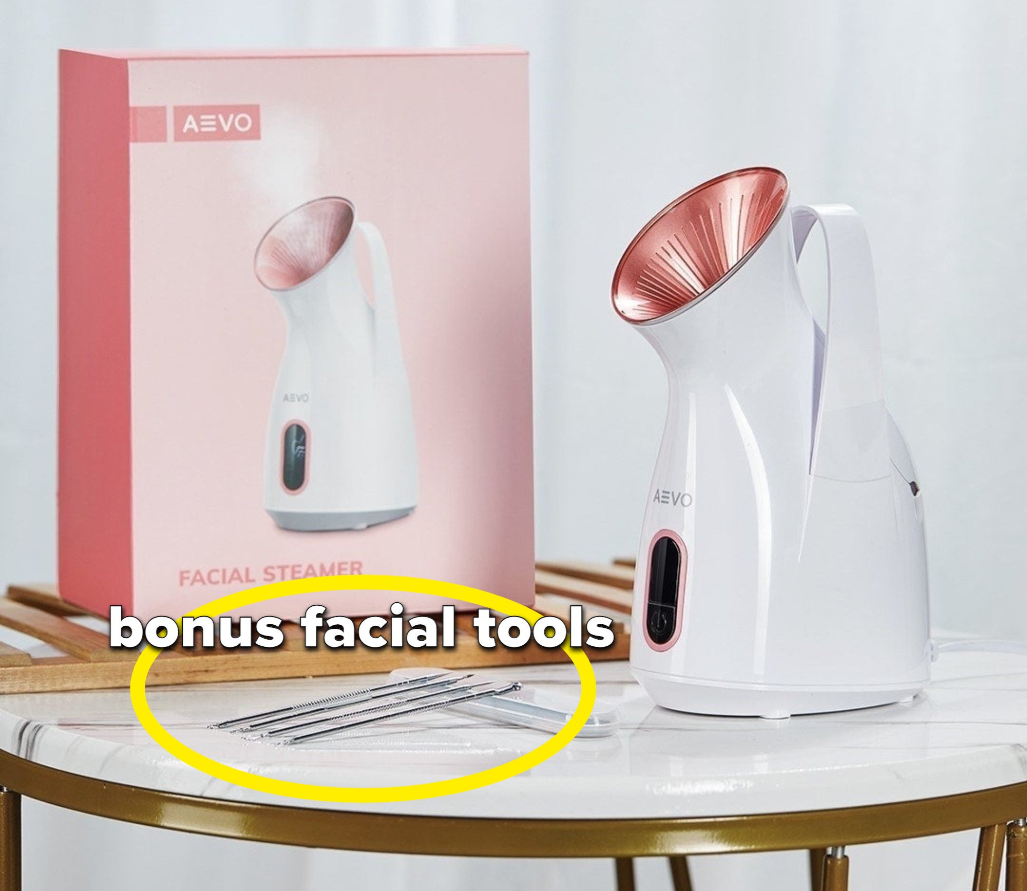 The facial steamer on a low table next to four face tools 