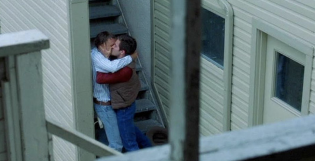 Jake Gyllenhaal and Heath Ledger&#x27;s characters sneaking a kiss outside in &quot;Brokeback Mountain&quot;