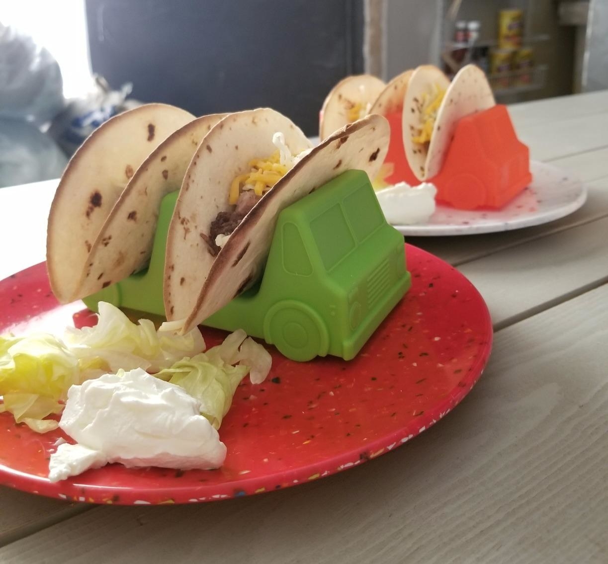 reviewer photo of a red and green plastic truck with two spaces to put taco shells in each 