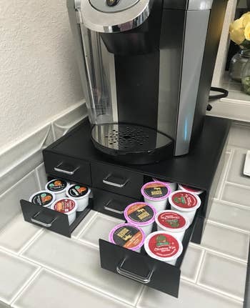 A reviewer photo of the same Keurig on the coffee pod holder with the drawers open and filled with K-cups 