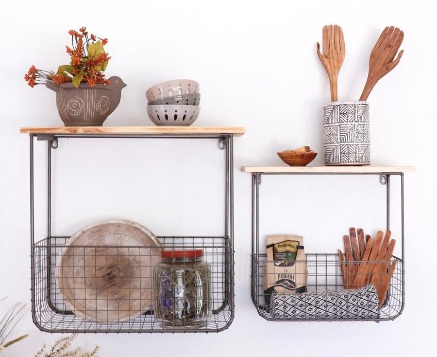 Two different sizes wooden shelves with connected wire storage baskets underneath filled with kitchen supplies 
