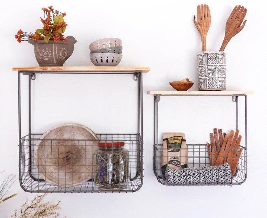 Two different sizes wooden shelves with connected wire storage baskets underneath filled with kitchen supplies