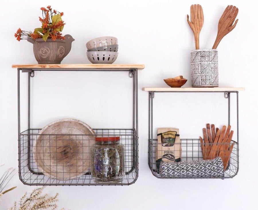 Two different sizes wooden shelves with connected wire storage baskets underneath filled with kitchen supplies 