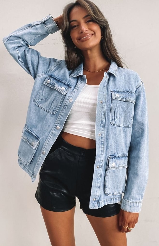 model in the light wash denim jacket with snap button closure and large pockets