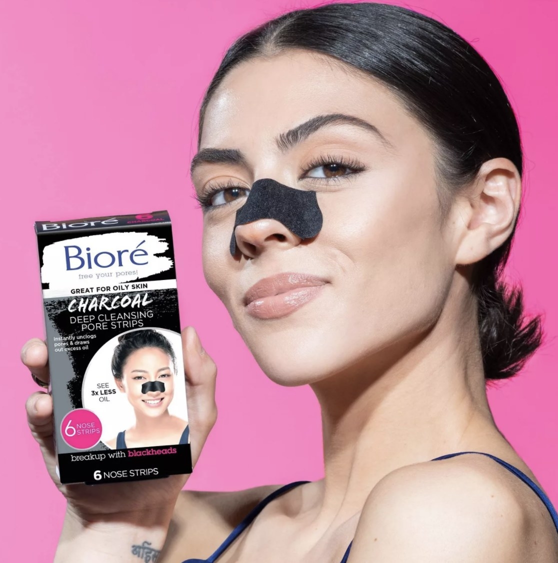 a model with a pore strip on their nose holding the box of pore strips