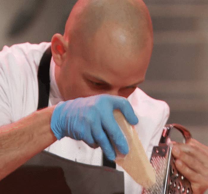 Man furiously grating cheese