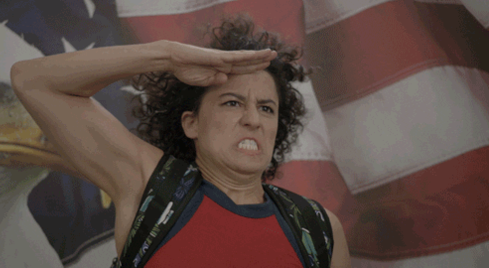 Woman saluting in front of an American flag