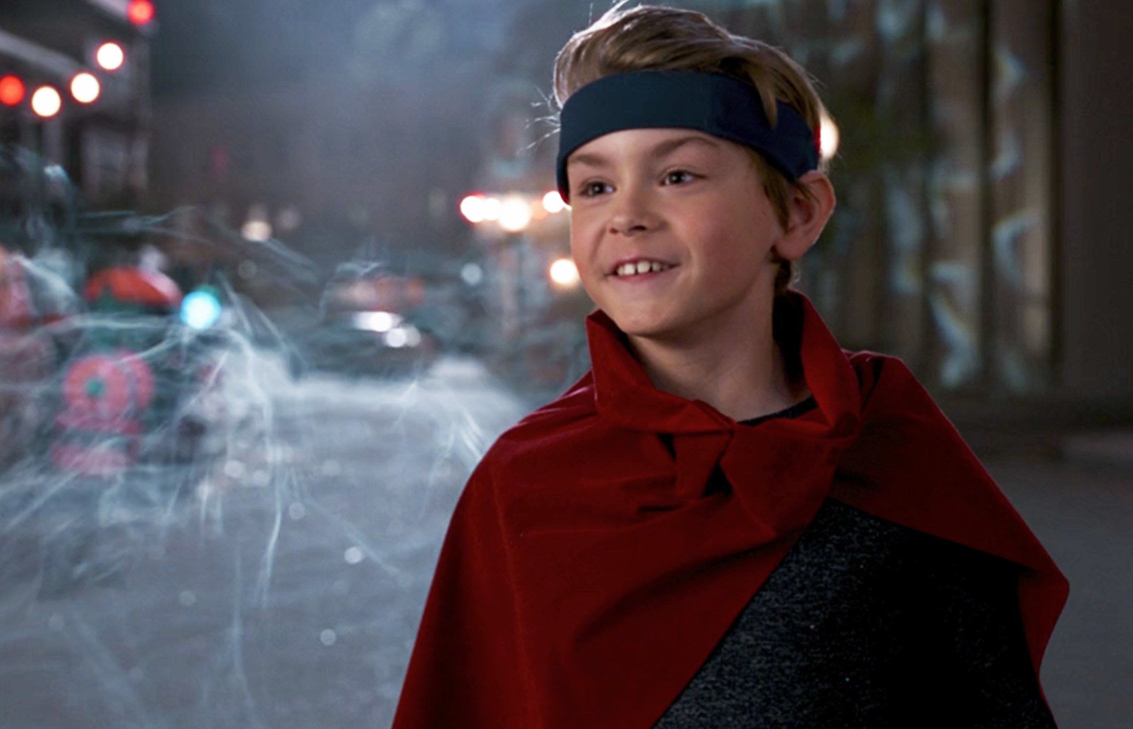 Billy&#x27;s costume includes a red cape and a blue headband that circles his forehead