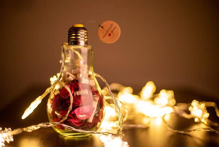 A bulb filled with scrolls, rose petals, and fairy lights