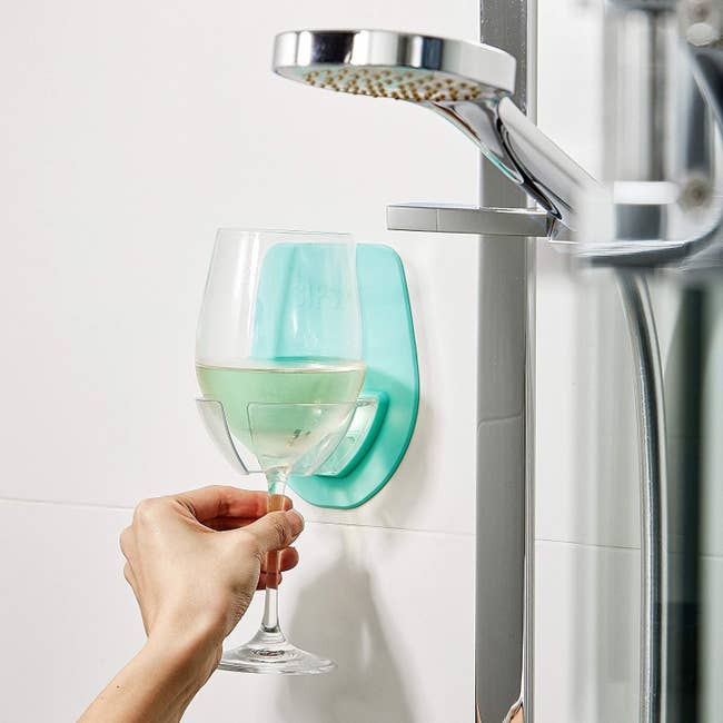 a model using the silicone holder to put their wine glass in the shower