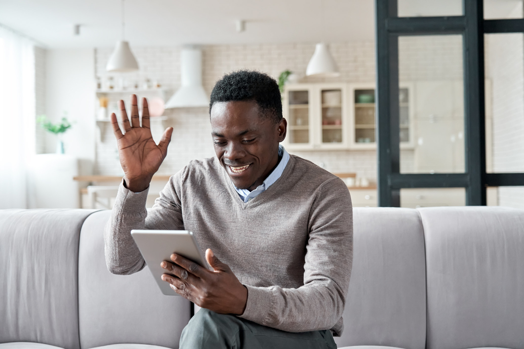 Personne faisant un signe de la main devant l’écran d’une tablette