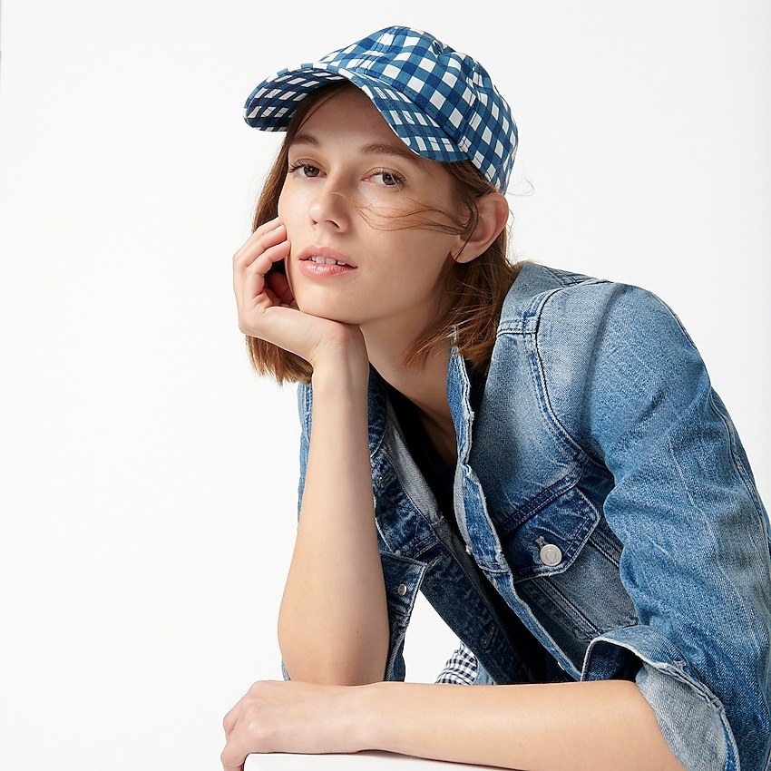 model wearing blue and white gingham baseball cap