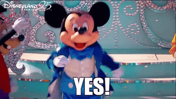 Mickey Mouse mascot jumping up and saying &quot;Yes!&quot;