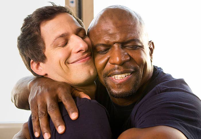 Andy Samberg and Terry Crews hugging in a scene from in BROOKLYN NINE-NINE