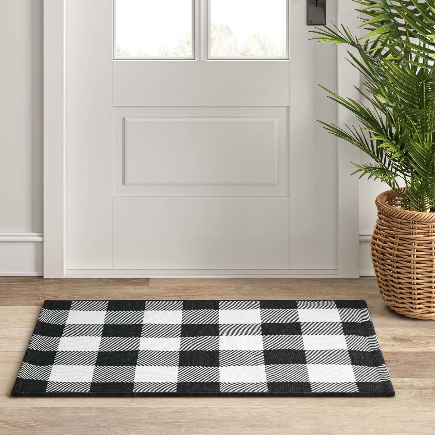The rug, which is rectangular, with a buffalo check pattern in black and white